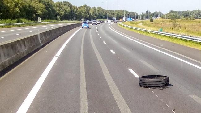 Vrachtwagen verliest band en botst in vangrail