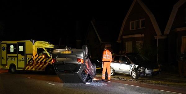 Auto botst op geparkeerde auto en vliegt over de kop