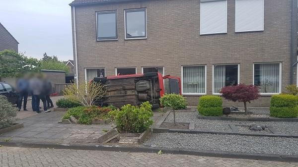 Auto belandt op de zijkant tegen woning na ongeval