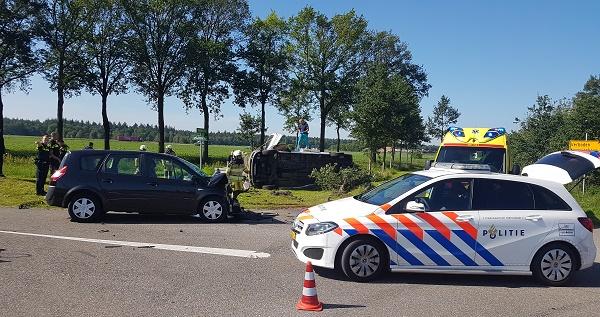 Auto over de kop na aanrijding op kruising