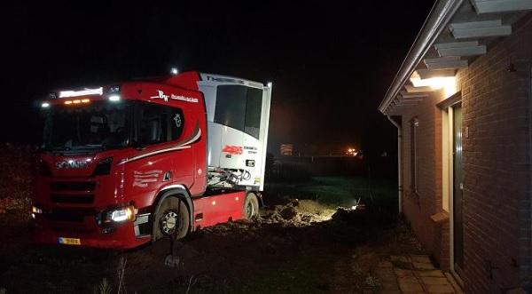 Vrachtwagen schiet door bosjes tuin in