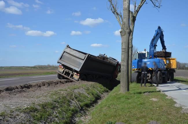 Vrachtwagen met zand raakt van de weg 