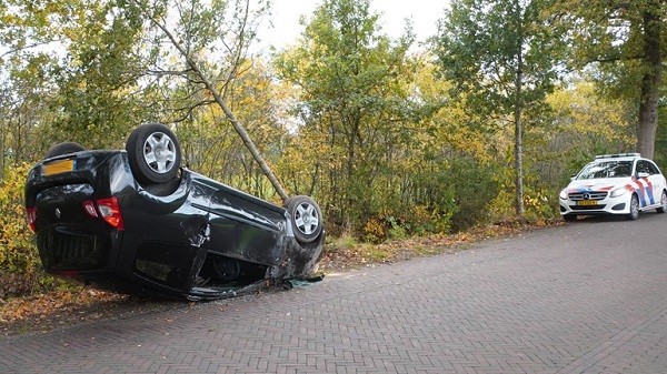 Auto op de kop na botsing met boom (video)