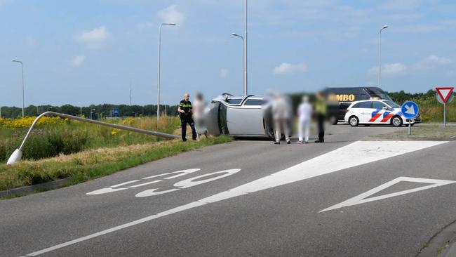 Auto met twee personen op de kant na botsing met lantaarnpaal (video)