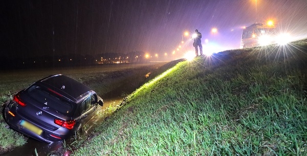 Auto de sloot in tijdens heftige regenbui op A37