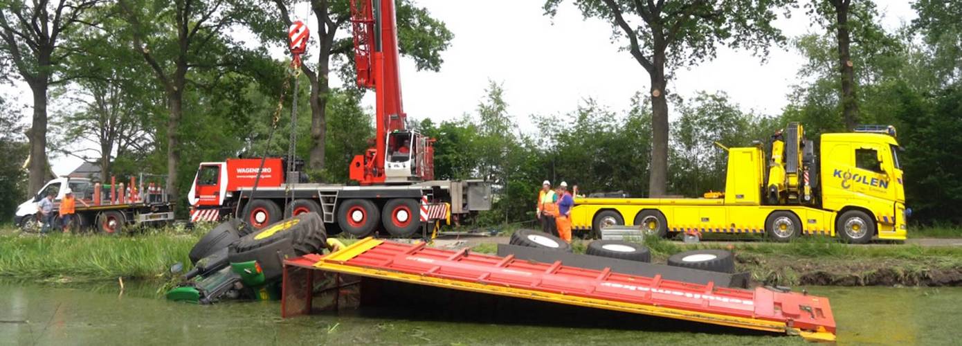 Trekker en aanhanger met gras belandt in de vaart na ongeval (video)