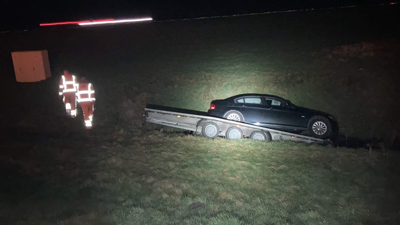 Aanhanger met auto schiet los en komt in bermsloot langs A28