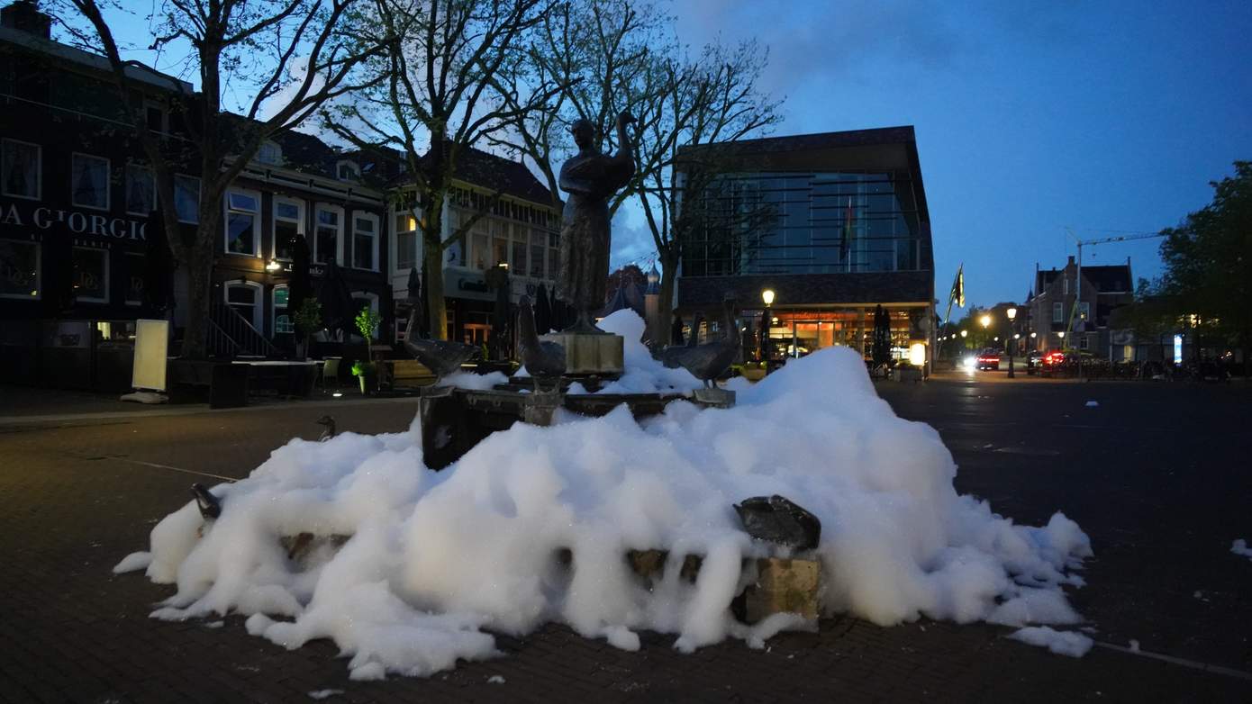 Onbekenden gooien zeep rondom beeld van 