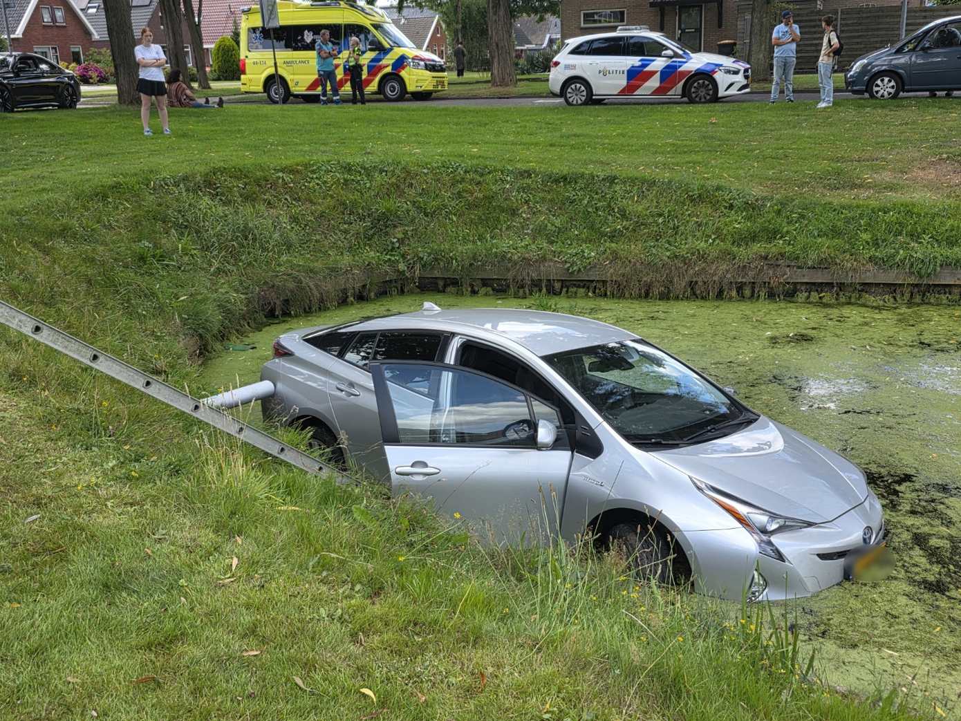 Auto raakt te water tijdens keren: buurtbewoners redden bestuurder uit water