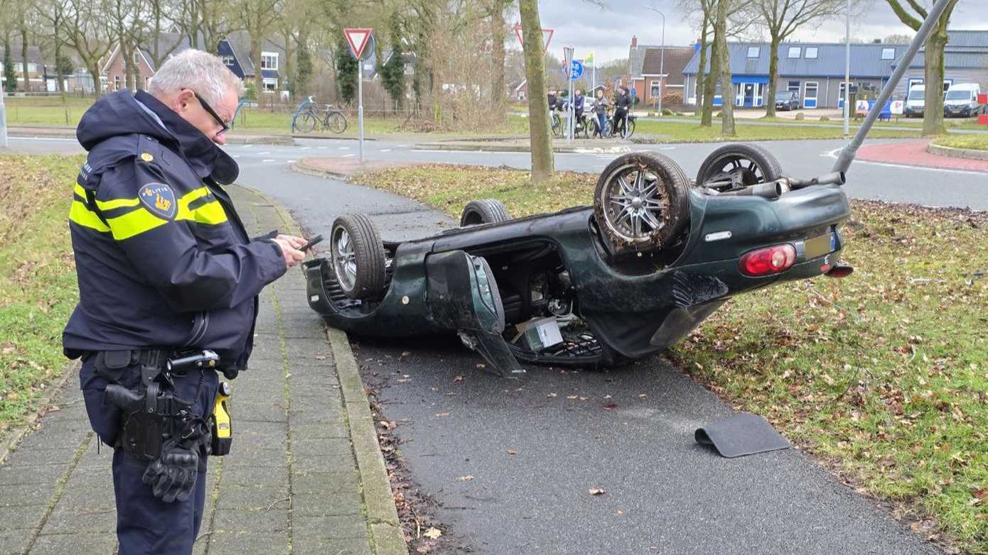 Auto slaat over de kop na botsing met lantaarnpaal