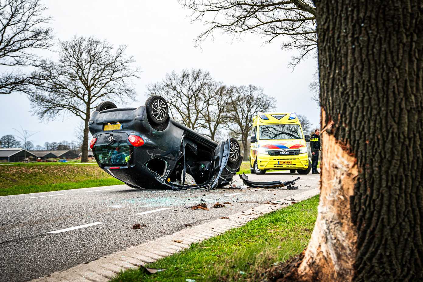 Auto op de kop na botsing met boom in Hoogersmilde